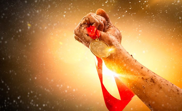 Mão erguendo uma medalha de ouro, simbolizando conquista e reconhecimento na carreira em Customer Success